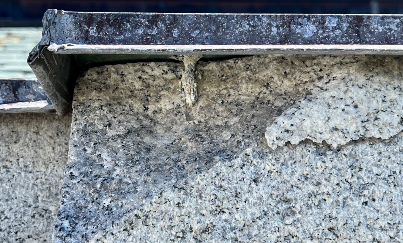 Detail image of broken stone piece with copper coping.