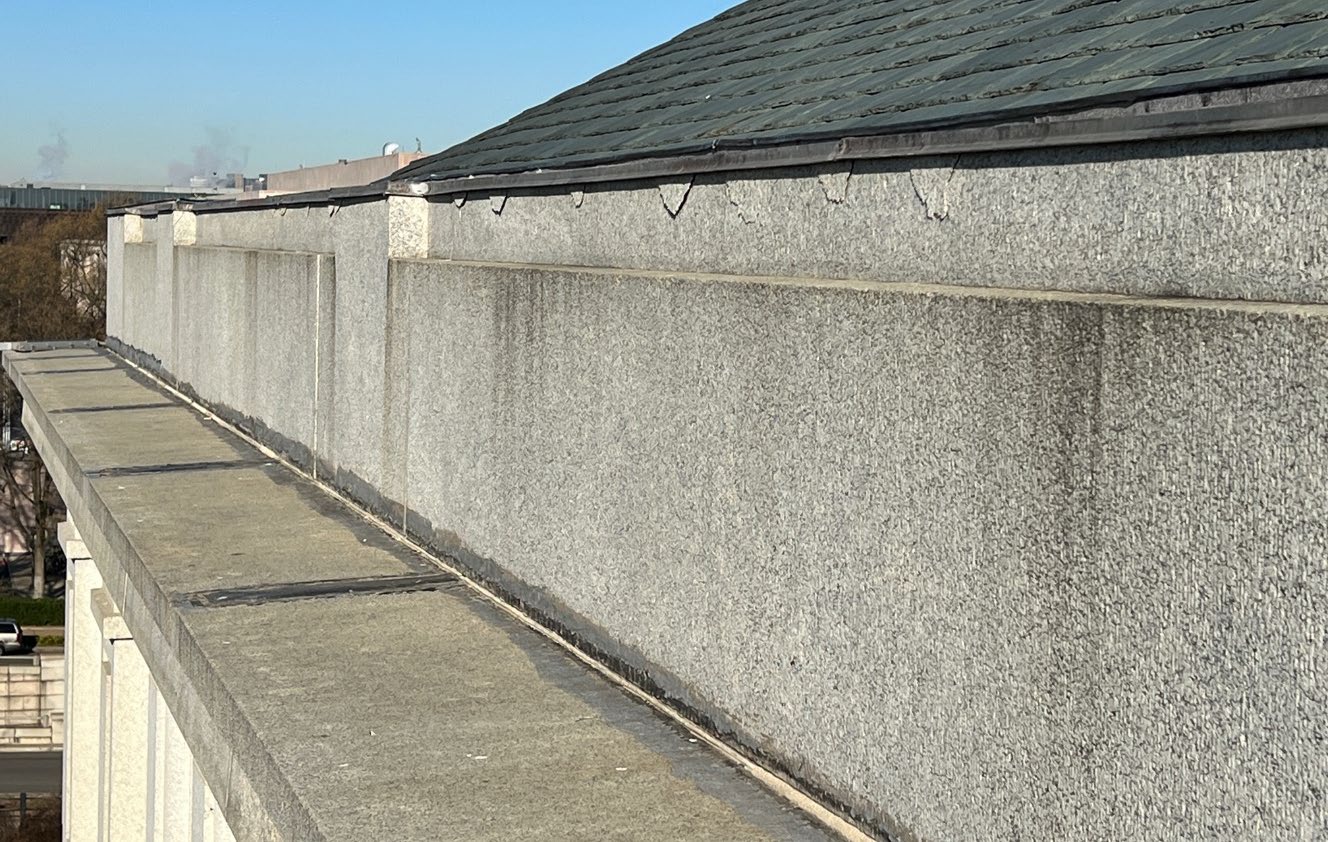 Detail image of a roof parapet with spalls.