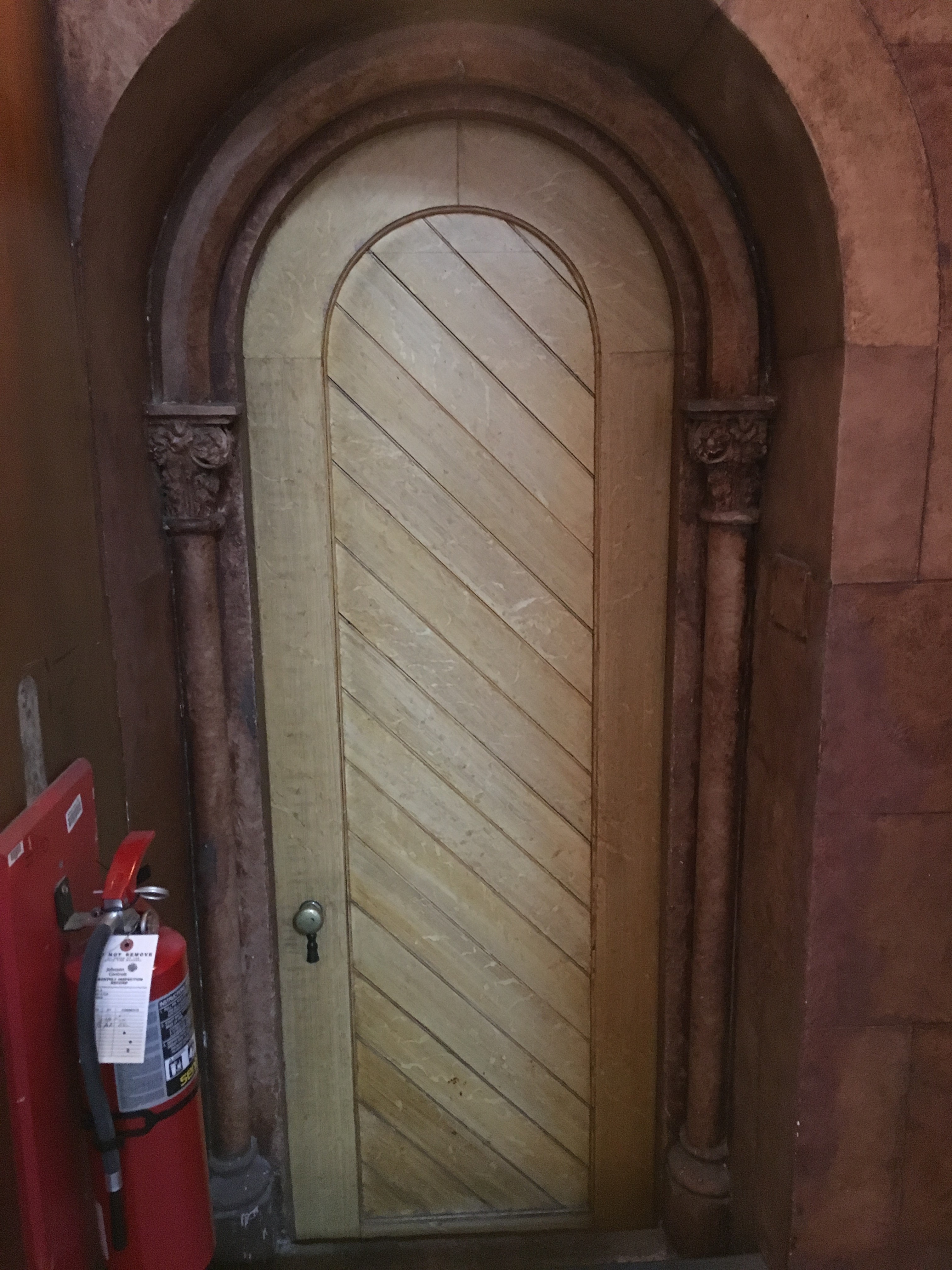 Interior wooden door with diagonal paneling. 