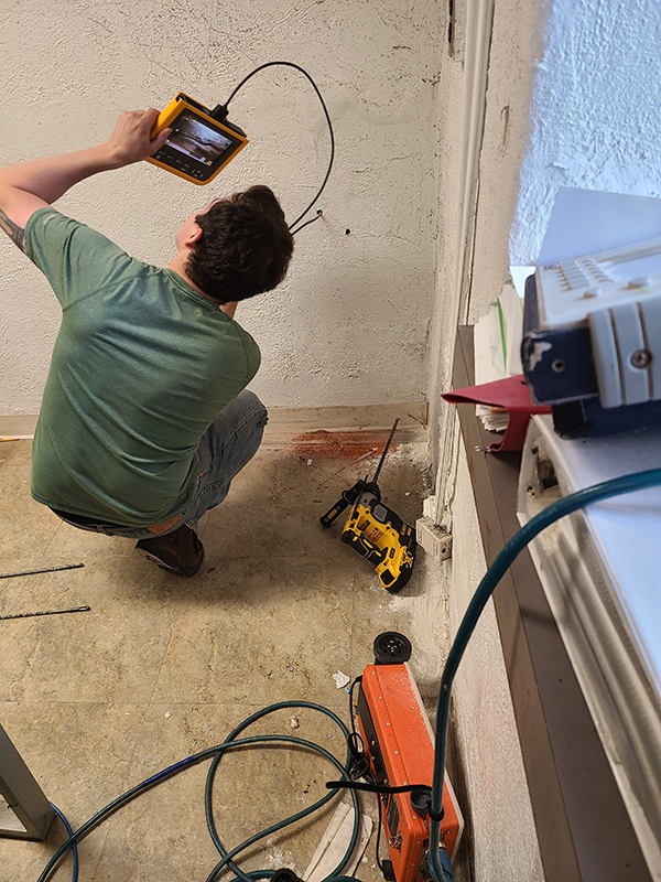 Holes were drilled in the north wall at the northeast corner in the basement of the East Wing and a fiber-optic videoscope was inserted.