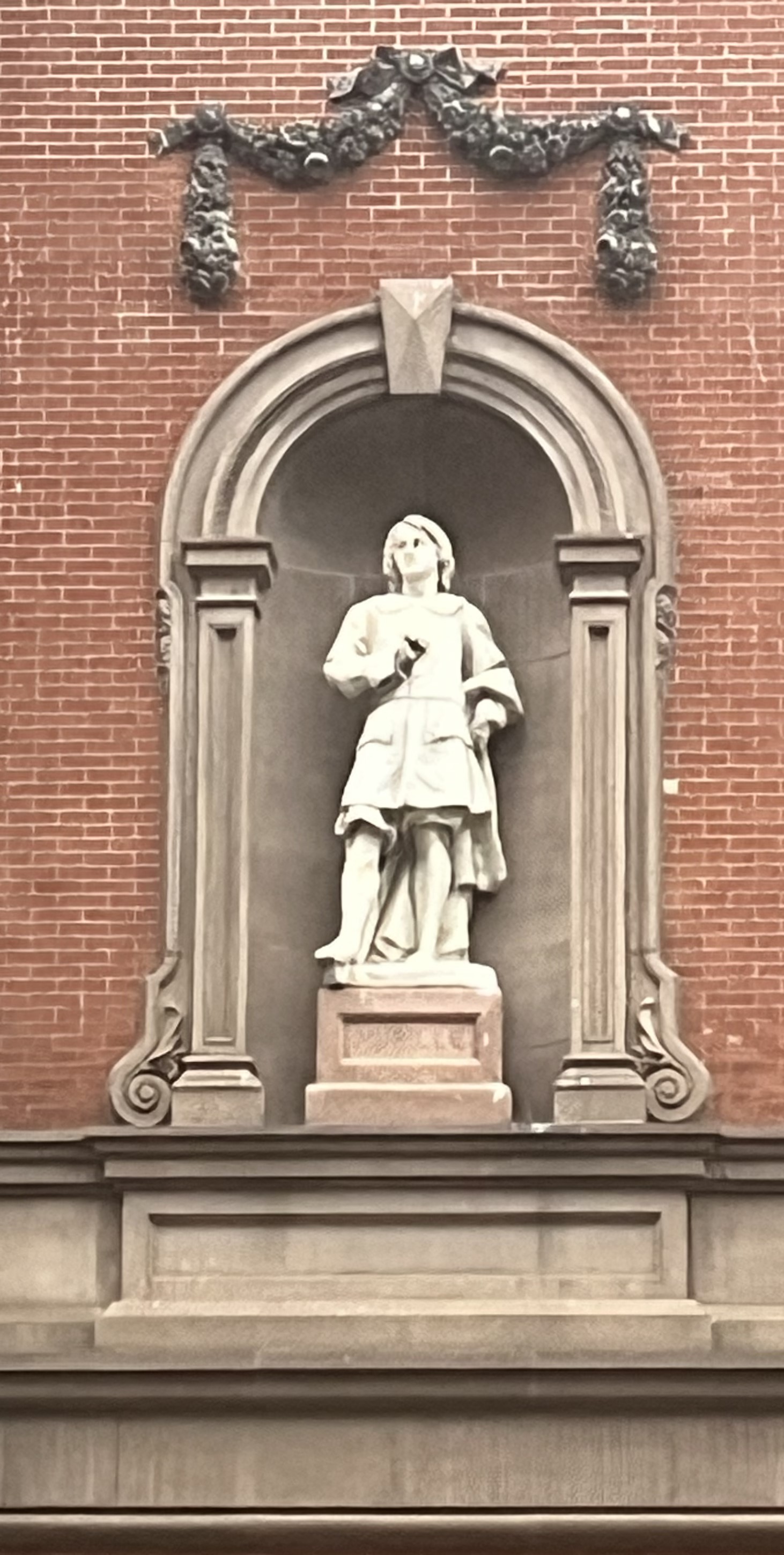 Statue in an exterior building niche.