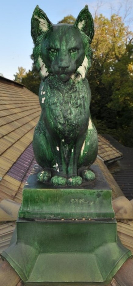 Image of a green terra cotta sculpture on a roof.